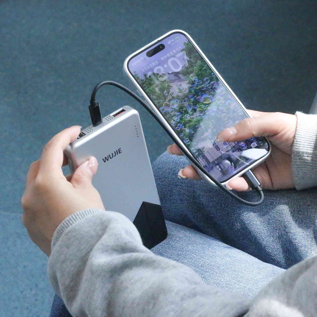 Charging a phone via a WUJIE power bank represents the sustained energy and connectivity that technology offers during mobile moments.